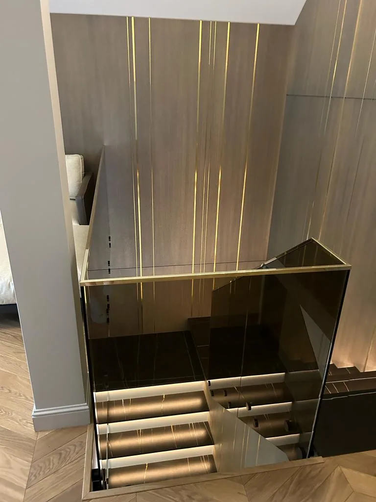 Turnkey custom furniture project in Illuminated Staircase Glass Railing Custom Interior by RPGroup